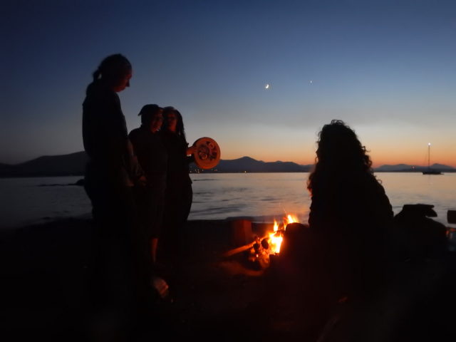 Group of people around a fire at sunset