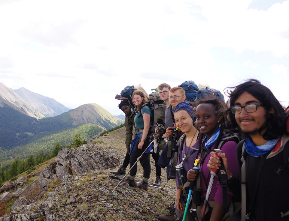 Group of people smiling on top of a mountain