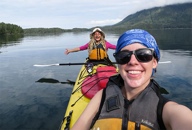 Image of 2 smiling teens in a tandem kayak