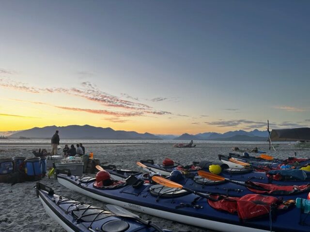 kayaks on a beach at sunset