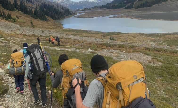 teens hiking on mountain with backpacks